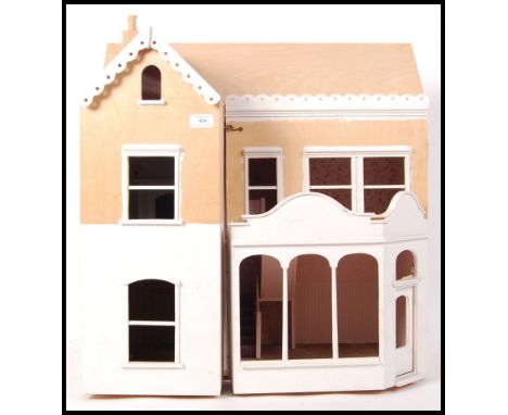 A 20th century part finished dolls house of plywood construction being wired for lighting. The front opening revealing 4 room
