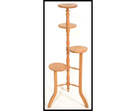 A 20th Century four tier pine plant stand / torchere, central turned column raised on tripod splayed feet.&nbsp;Measures: 112