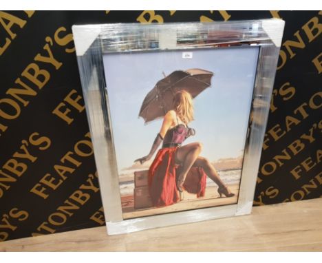 A GLASS OVERLAY PRINT DEPICTING A BURLESQUE DANCER ON A BEACH AFTER KELLY 78.5 X 58CM