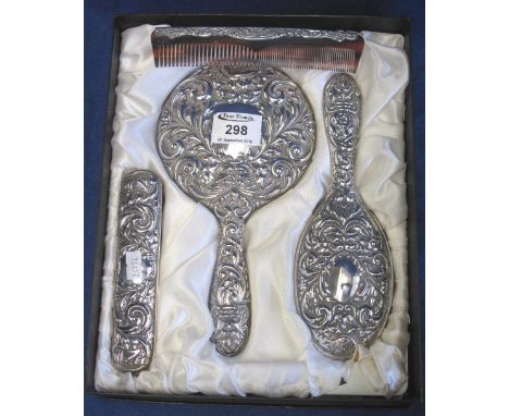 Silver repousse decorated dressing table set comprising: two brushes; comb and hand mirror, in original fitted box, Birmingha