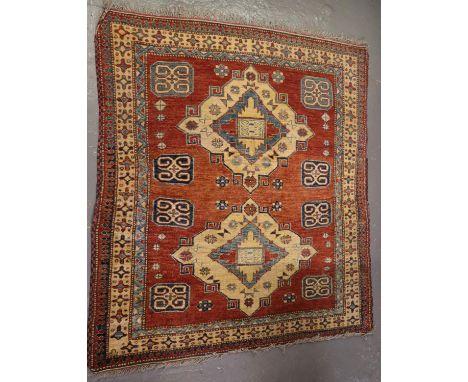 20th century Middle Eastern design carpet on a salmon ground with two central medallions having geometric and stylised floral