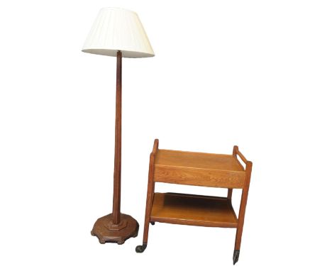 In the style of Brynmawr, an oak two tier trolley with pull-out drawers to each side, standing on metal wheels, together with