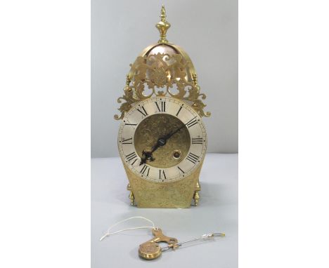 Dutch style brass lantern clock, having baluster finial above brass bell, pierced figural pediment with silvered Roman chapte