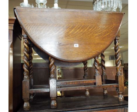 An oval oak gate legged table on barley twist legs, 2'6 wide 