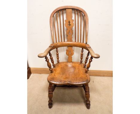 A high backed elm Windsor elbow chair with stick and patterned back 