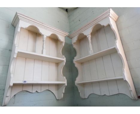 A pair of white painted three tier wall shelf units 