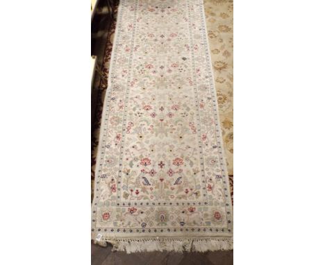 A 13'6 cream and patterned carpet runner