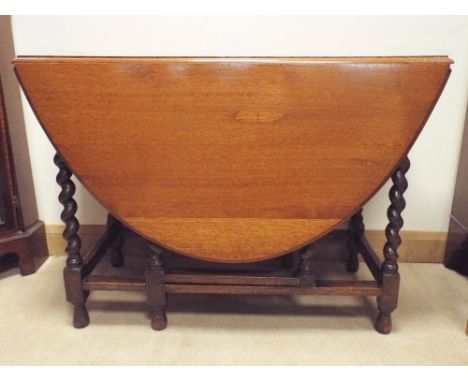 An oval oak gate leg dining table on barley twist legs 3'6 wide 