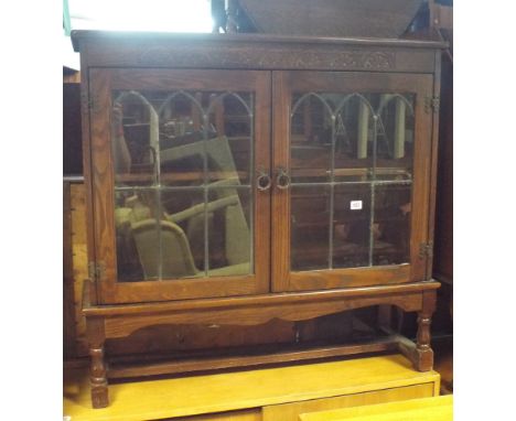 A reproduction oak low bookcase with leaded light glazed doors 