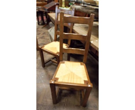 A set of six oak framed ladder back dining chairs with rush seats 
