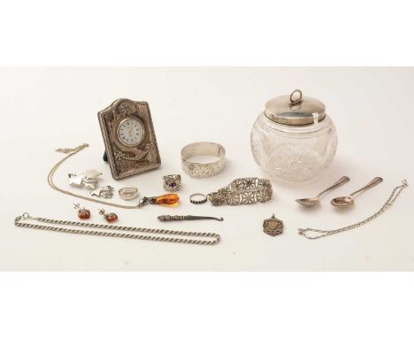 A selection of silver items, to include: a silver covered cut glass preserve jar; a dressing table clock by R. Carr; a bangle