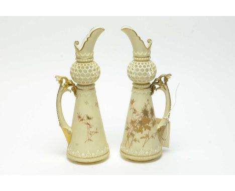 A pair of Royal Worcester ewers, each with pierced reticulated spherical knop over a tapered conical body decorated with gilt