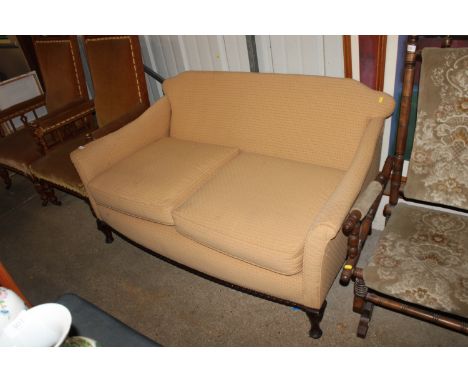 An upholstered two seater sofa raised on cabriole supports