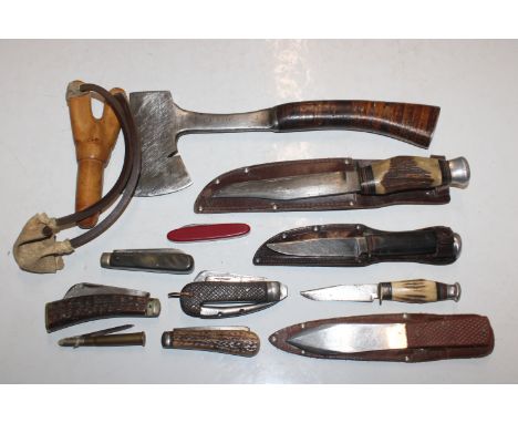 A box containing various penknives, pocket knives, a catapult, an axe