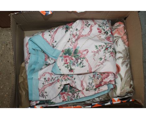 A roll of upholstery fabric together with a bed cover and matching curtains