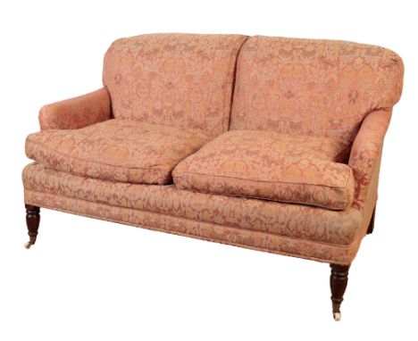 A VICTORIAN UPHOLSTERED SETTEE in a cotton upholstery decorated with birds and floral motifs on a salmon ground, with turned 