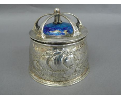 Omar Ramsden &amp; Alwyn C.E. Carr - A chased silver and blue enamel topped box with crown style top, decoration of Galleon, 