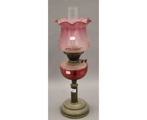 A Victorian brass and cranberry glass oil lamp. 61 cm high overall.