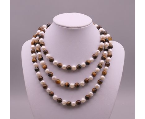 A tigers eye and pearl necklace. Approximately 116 cm long.