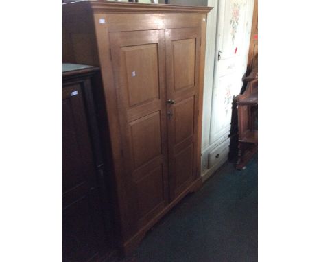 An Arts and Crafts style hand crafted two door wardrobe, of recent manufacture, joined construction, fitted with two three-pa