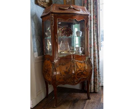  A 19th Century French Bombe walnut vitrine display cabinet, in the Rococo Revival style, having a glazed door, the lower sec