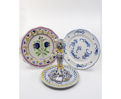 A collection of Faience plates and dishes, blue and white and polychrome decoration along with a 19th century faience candles