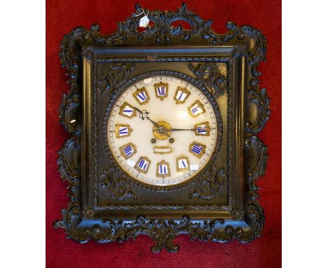 A 19th Century French ornately framed wall clock, enamel shields painted blue Roman numerals, mounted a gilt metal, dark stai