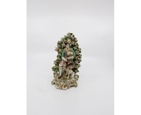 A Derby bocage figure of a musician playing bagpipes with his dog at his feet. c.1765. Size 20.5cm. high Condition; both hand