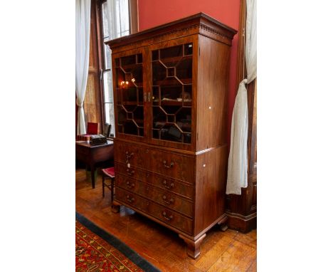  A George III mahogany secretaire linen press, the upper section with a fretwork geometric moulded edge and a repeated archit