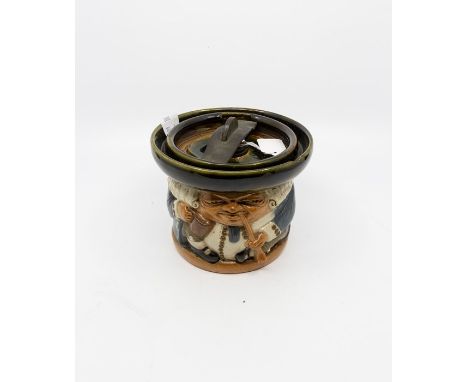 A Royal Doulton Lambeth salt glazed stoneware tobacco jar in the form of a Toby smoking pipe and holding ale, lid with some p