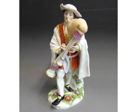 A Meissen figure of a Savoyard Bagpiper, dressed in a white cloak and breaches and a red coat, with applied flowers to the ba