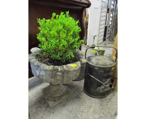 three vintage galvanized metal watering cans and a weathered composition stone garden planter 