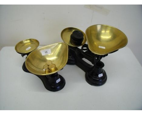 Two sets of brass and cast metal kitchen scales with associated weights 