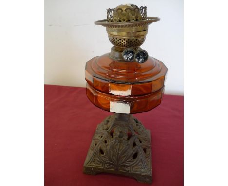 19th/20th C oil lamp with amber glass reservoir and cast metal base 