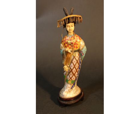 A Chinese sculpture of a lady with hat, standing on wooden base; gilded copper with rich multicoloured enamel and ivory head 