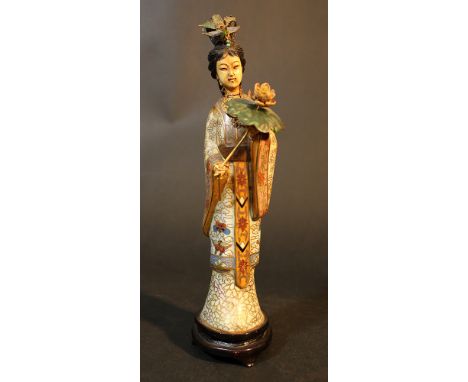 A Chinese sculpture of a lady with lotus blossom, standing on wooden base; gilded copper with rich multicoloured enamel and i