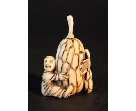 Asian ivory Netsuke of a man holding a fruit with leaves; on the reverse signature and two holes for mount; ivory carved, pos