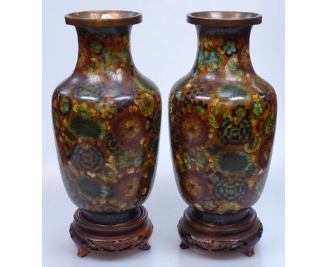 A pair of Chinese floral decorated cloisonne enamel vases on wooden stands, height 10" 