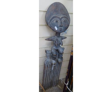 A large African Ashanti ornamental carved wood comb, surmounted by a seated figure, height 33" 