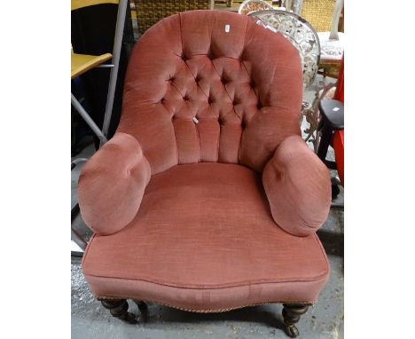 A Victorian button-back upholstered armchair, on turned mahogany legs 
