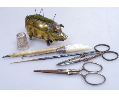 A Victorian brass pig pin cushion, length 3", sewing scissors, a mother-of-pearl button-hook etc 
