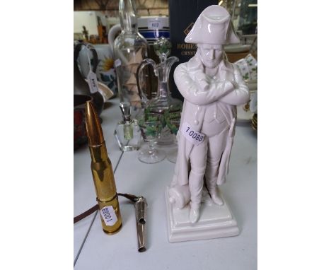 A German porcelain Napoleon, a Dowler whistle, and a brass cartridge cigarette lighter 