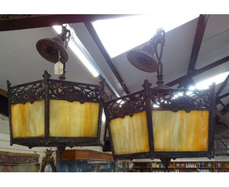 A pair of hexagonal metal-framed coloured glass ceiling light fittings, 14" across 