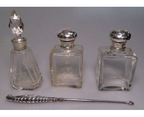 A pair of Art Nouveau silver-topped bottles, a silver-mounted scent bottle, and a silver-handled button hook 