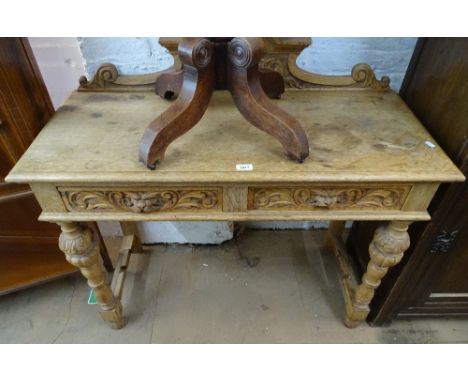 A Victorian light oak hall table, with raised carved back, 2 lion mask carved frieze drawers, raised on turned legs, W107cm 