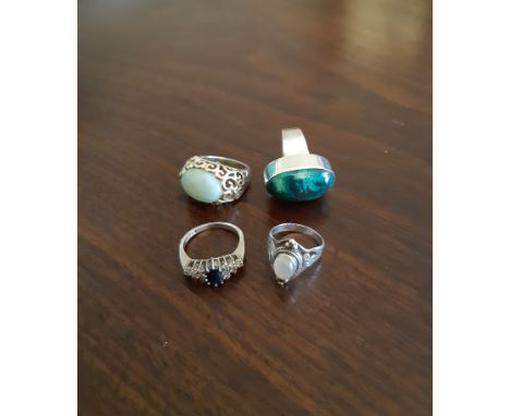 Four silver rings, variously set with moonstone, malachite and other stones