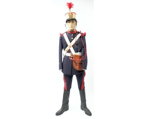 A Spanish Royal Guard uniform: comprising peaked cap with red feather plume and gilt cap badge, blue cloth tunic with red clo