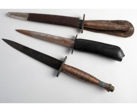 Two Fairbairn Sykes pattern knives:  Third Pattern with cast ribbed grip, in brown leather scabbard, together with a Fairbair