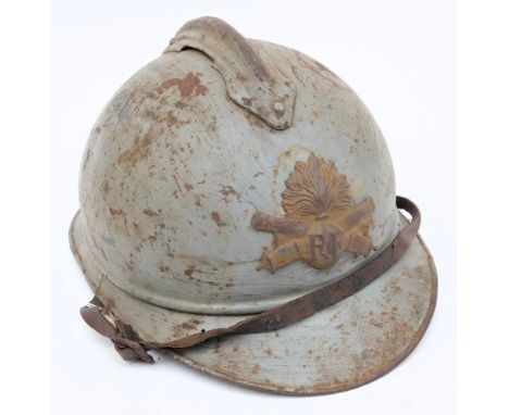 A WWI French Artillery Adrian pattern steel helmet: painted light blue with attached comb and  crossed cannon helmet plate, w