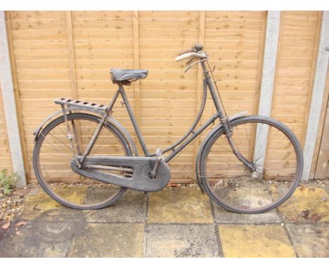 A 1930s Swift bicycle: step through frame, plated handlebars, bar brakes, black leather saddle, fitted rear pannier, chain gu